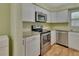 Modern kitchen, featuring stainless steel appliances and white cabinetry at 13 Villa Villar # 0, Deland, FL 32724