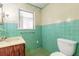 Small bathroom with teal tile and wood vanity at 724 N Oleander Ave, Daytona Beach, FL 32118