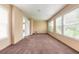 Empty sunroom with ample natural light and brown carpet at 724 N Oleander Ave, Daytona Beach, FL 32118