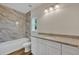 Bathroom with marble-look tile, granite countertop and white cabinets at 210 E Baxter St, De Leon Springs, FL 32130