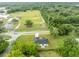 Aerial view showing a new home with a large backyard, located near a road and surrounded by lush greenery at 210 E Baxter St, De Leon Springs, FL 32130