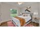 Bedroom with wood-look floors, ceiling fan, and window with view at 210 E Baxter St, De Leon Springs, FL 32130