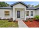 Modern front entrance with black door and red mulch landscaping at 210 E Baxter St, De Leon Springs, FL 32130