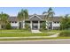 Community pool and clubhouse with palm trees and lush landscaping at 6287 Woodhaven Village Dr, Port Orange, FL 32128