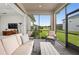 Relaxing screened porch with patio furniture, overlooking a grassy backyard at 6287 Woodhaven Village Dr, Port Orange, FL 32128