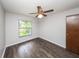 Bright bedroom with wood-look floors, ceiling fan, and large window at 34 Fairway Dr # 1, Debary, FL 32713