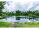Scenic view of a tranquil lake, lush greenery, and a partly cloudy sky at 34 Fairway Dr # 1, Debary, FL 32713
