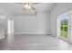 Bright living room with vinyl plank flooring, ceiling fan, and sliding glass door leading to backyard at 1790 17Th St, Orange City, FL 32763