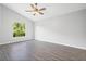 Well-lit bedroom featuring vinyl plank flooring, a ceiling fan, and a large window at 1790 17Th St, Orange City, FL 32763