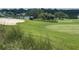 Golf course view with sand trap, players, and golf carts at 824 Silver Oak Ave, The Villages, FL 32159