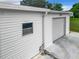 White garage exterior with single door and concrete at 824 Silver Oak Ave, The Villages, FL 32159