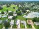 Aerial view showing a home near a lake and golf course in a residential community at 824 Silver Oak Ave, The Villages, FL 32159