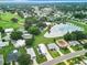 Aerial view of a home nestled in a community with a lake and golf course nearby at 824 Silver Oak Ave, The Villages, FL 32159