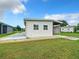 White mobile home with carport, landscaped yard, and spacious patio at 824 Silver Oak Ave, The Villages, FL 32159