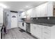Updated kitchen featuring white shaker cabinets, granite counters, and gray tile backsplash at 3660 Grand Ave, Deland, FL 32720