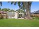 Back of house with patio and large tree at 3457 Martingale Ct, Port Orange, FL 32129