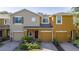 Tan and mustard-colored two-story townhome with two-car garage at 5541 Rutherford Pl, Oviedo, FL 32765