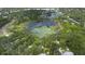 Aerial view of a neighborhood with a large pond in the center at 288 Silverstone Dr, Orange City, FL 32763