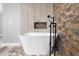 Elegant bathroom featuring a modern freestanding bathtub and stone wall at 288 Silverstone Dr, Orange City, FL 32763