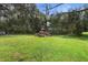 Spacious backyard with grassy area and mature trees at 288 Silverstone Dr, Orange City, FL 32763