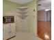 Kitchen features white cabinets, corner shelving, and a view to the living room at 47 Villa Villar Ct # 470, Deland, FL 32724