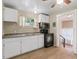 Kitchen with white cabinets, a black stove, and a double sink at 2300 Calloway Dr, Orlando, FL 32810