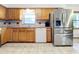 Kitchen with wood cabinets, stainless steel appliances, and tile floor at 106 N Frederick St, Pierson, FL 32180