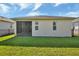 Back of house with screened patio, fenced yard, and lawn at 1370 Red Clover Ln, Deland, FL 32724