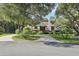 A two-story home with a long driveway, surrounded by lush trees at 1582 Covered Bridge Dr, Deland, FL 32724