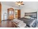 Bedroom with a ceiling fan, wood floors and an antique armoire at 1582 Covered Bridge Dr, Deland, FL 32724