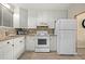 White kitchen cabinets, granite countertops, and white appliances at 2711 N Halifax Ave # 296, Daytona Beach, FL 32118