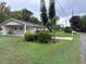 View of a single story home with a carport and landscaped yard at 1871 Riveredge Dr, Astor, FL 32102