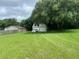 Large backyard with a detached garage and a large tree at 1415 Talton Ave, Deland, FL 32720