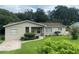 Tan single story house with a well-manicured lawn and driveway at 1415 Talton Ave, Deland, FL 32720
