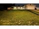 Night view of a single-story house with a well-maintained lawn at 1757 W Acadian Dr, Deltona, FL 32725
