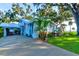 Quaint light blue house with covered patio and tropical landscaping at 111 Fleming Ave, Port Orange, FL 32127