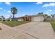Single-Gathering home with brick exterior, palm trees, and a driveway at 22 Morning Star Ave, Ormond Beach, FL 32176