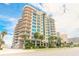 Ocean Villas building exterior with palm trees at 3703 S Atlantic Ave # 501, Daytona Beach Shores, FL 32118