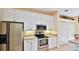 Modern kitchen with white cabinets, stainless steel appliances and an eat-in area at 3709 Donegal Cir, Ormond Beach, FL 32174
