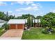 Red home with metal roof, two-car garage, and landscaped yard at 980 Bluebird Ter, Deltona, FL 32725