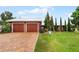 Red two-car garage home with brick driveway and landscaped yard at 980 Bluebird Ter, Deltona, FL 32725