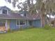 Ranch style home exterior with dark roof, stone accents, and lush landscaping at 573 Pelican Bay Dr, Daytona Beach, FL 32119