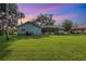 Home with large backyard, grassy lawn, and palm trees at sunset at 573 Pelican Bay Dr, Daytona Beach, FL 32119