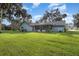 Back of house showing a large yard and screened porch at 573 Pelican Bay Dr, Daytona Beach, FL 32119