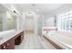 Bathroom with double vanity, bathtub, and glass shower at 2291 Henry Ln, Deltona, FL 32738