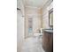 Convenient bathroom with beige tile, a single vanity, and access to the pool at 2291 Henry Ln, Deltona, FL 32738