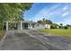 Light blue house with carport and a spacious lawn at 1402 Talton Ave, Deland, FL 32720