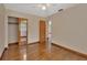 Bedroom with hardwood floors, mirrored closet doors, and access to another room at 1402 Talton Ave, Deland, FL 32720