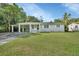 Charming light green house with carport and landscaped lawn at 1402 Talton Ave, Deland, FL 32720
