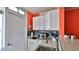 Small galley kitchen with white cabinets, blue tile backsplash, and stainless steel appliances at 935 S Atlantic Ave # 206, Daytona Beach, FL 32118